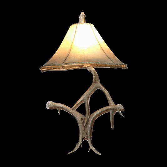 Antler table lamp with oiled rawhide shade on black background